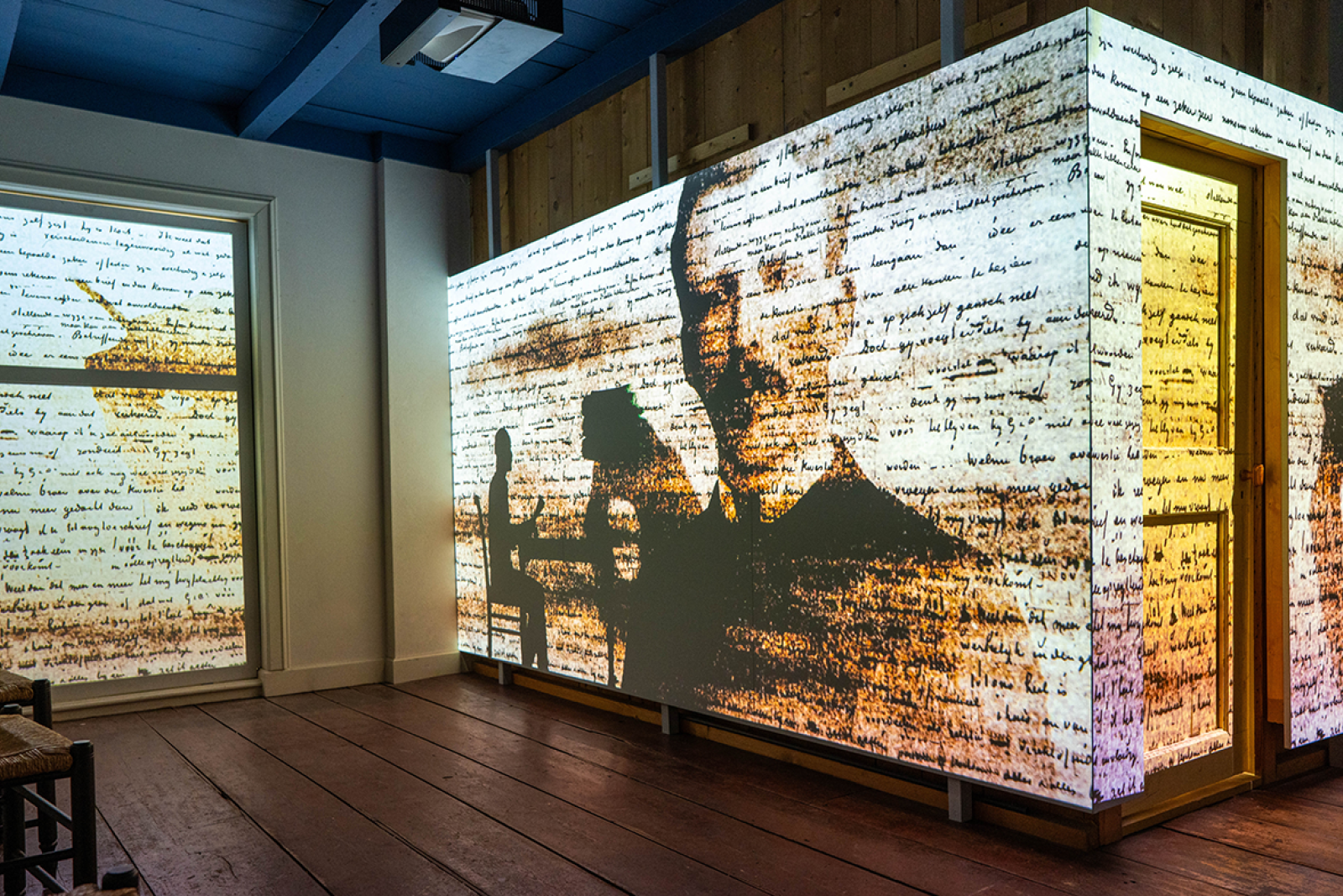 Projectie op muur van foto's en handschrift