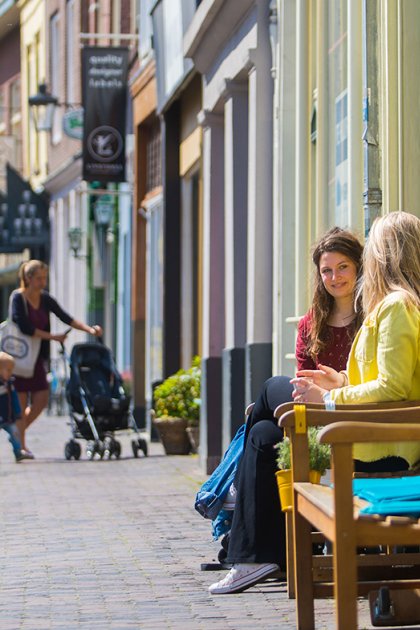 Winkelstraat in Museumkwartier Utrecht twee dames op een bankje in de zon