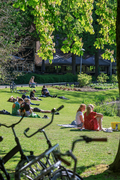 Mensen in het Wilhelminapark in Utrecht genieten van het mooie weer