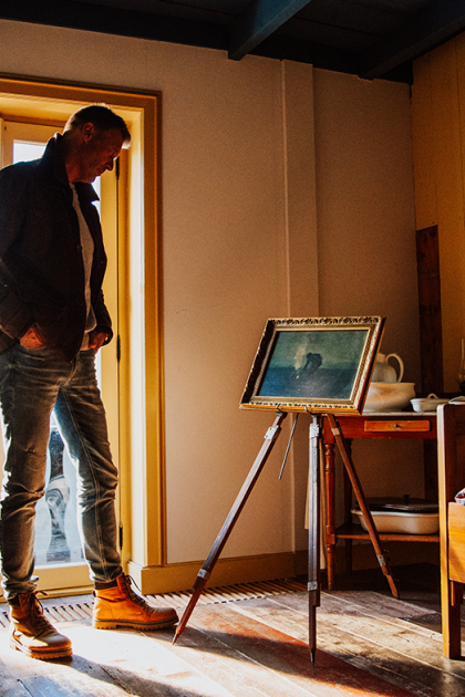 Man bekijkt schilderij op standaard