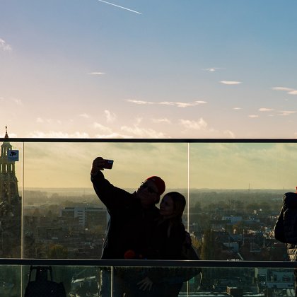 Bezoekers genieten van het uitzicht over de stad vanaf het dakterras van Forum Groningen