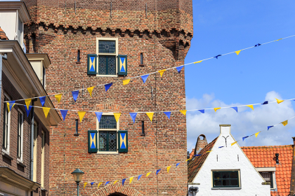Dijkpoort in Hattem, straatje versierd met blauwe en gele vlaggetjes.