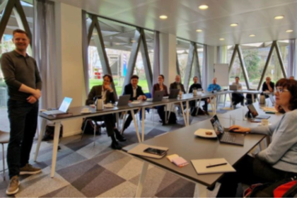 Kennis lab sessie - deelnemers aan tafels luisteren naar spreker