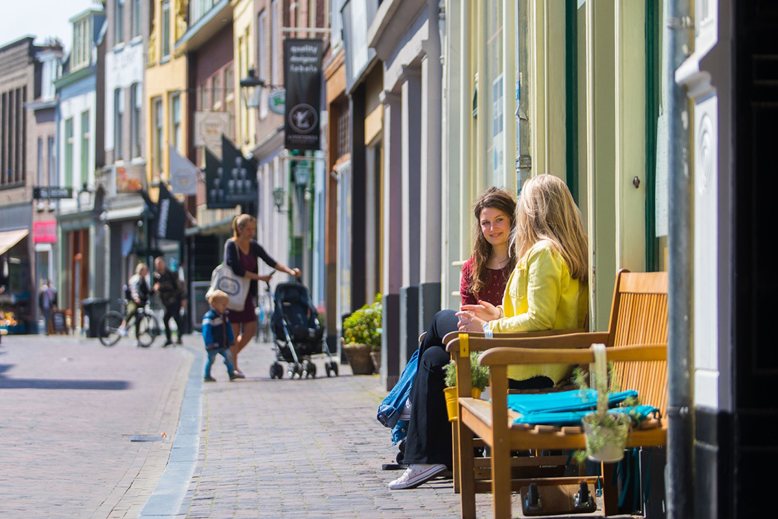 Winkelstraat in Museumkwartier Utrecht twee dames op een bankje in de zon