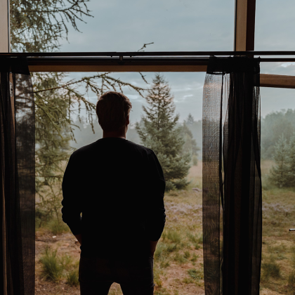 Man kijkt naar buiten vanuit deuropening in natuurgebied