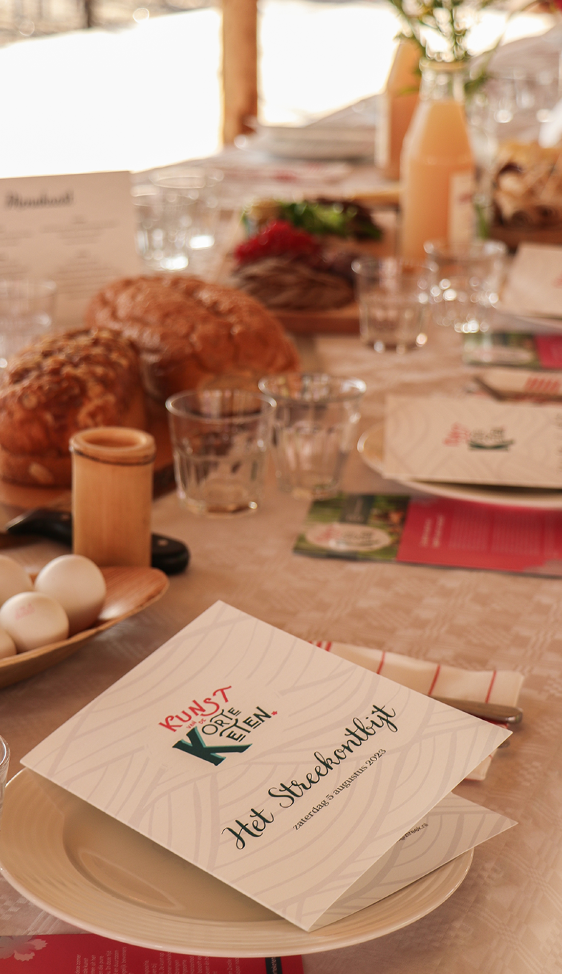Een gedekte tafel met streekproducenten en menukaart