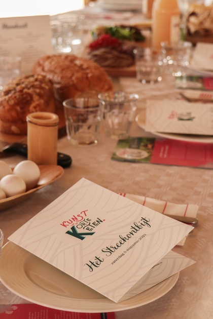Een gedekte tafel met streekproducenten en menukaart